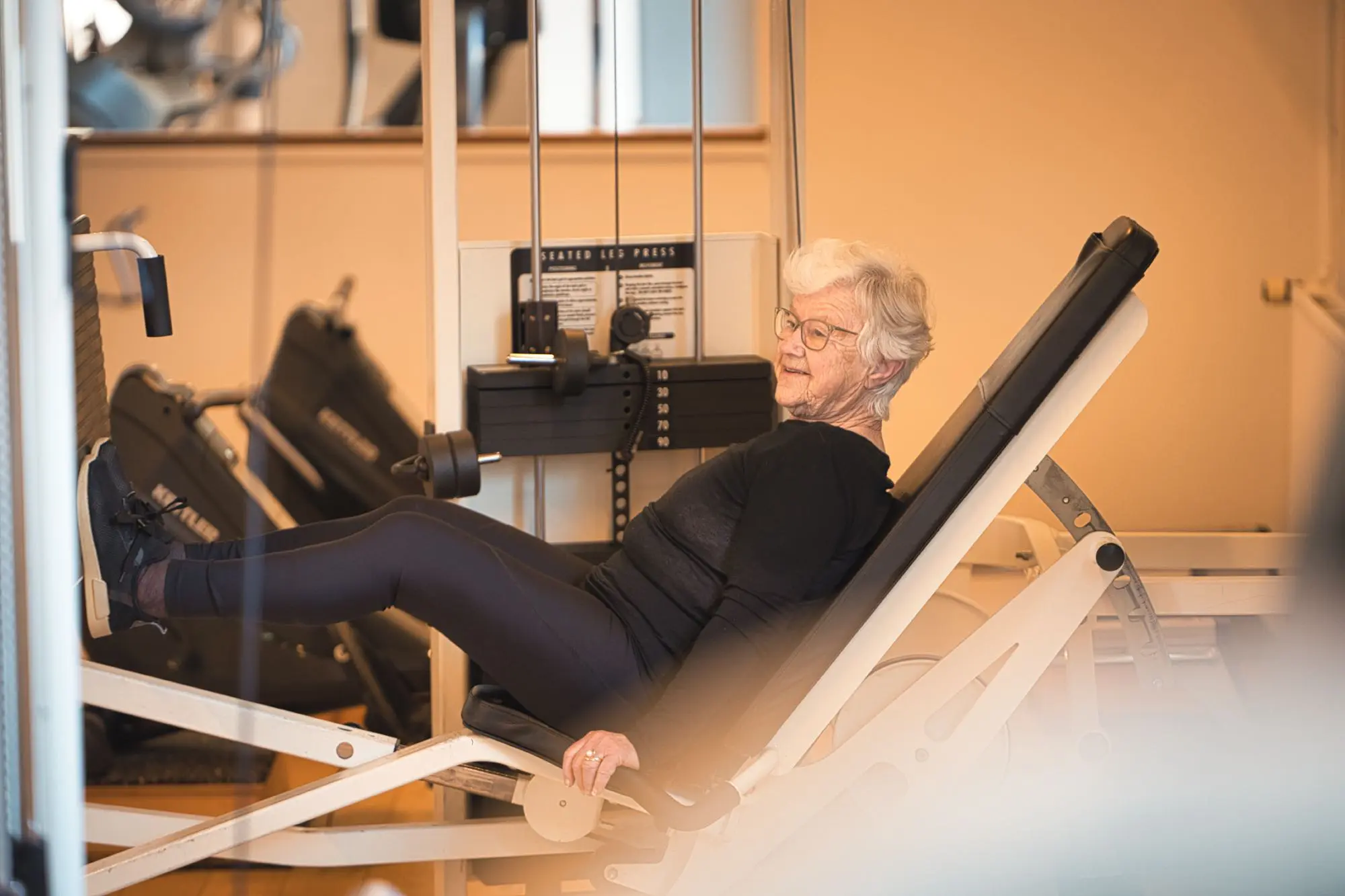 Medlem træner på styrkemaskine i Happy Hour Fitness